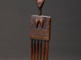 une image représentant un peigne en bois orné d'un visage