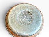a silver coin sitting on top of a white surface