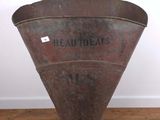 an old metal bucket sitting on top of a wooden floor next to a white wall