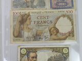 four different bank notes are on display in a glass case