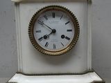 une petite horloge blanche posée sur une table