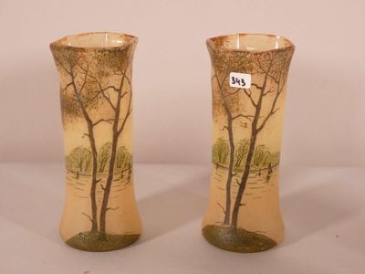 une paire de vases décorés d'arbres, posés sur une table