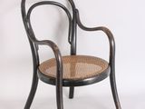 une chaise noire avec une assise en osier sur fond blanc