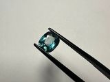 a close up of a pair of tongs holding a blue diamond