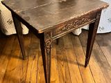 a small table with a wooden top on a wooden floor