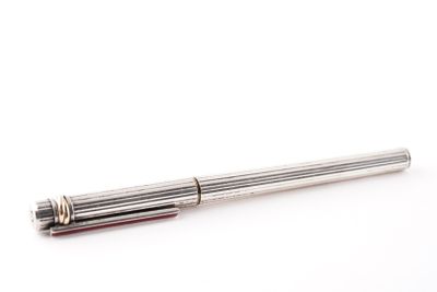 un gros plan d'un stylo sur une surface blanche avec un fond blanc
