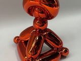 an orange balloon shaped like a man holding a baseball bat