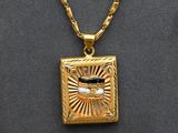 a close up of a gold necklace with a picture of a man