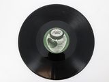 vinyl record on a white surface with a green label