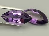 Des pierres précieuses d'améthorate violettes sont vendues à l'aide d'une paire de pinces.