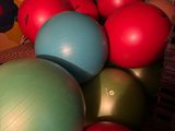 a pile of exercise balls on the floor in a room