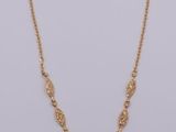 a gold necklace with a circular pendant on a chain