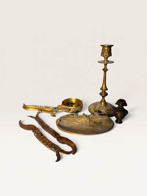 brass candlesticks and other brass objects on a white background