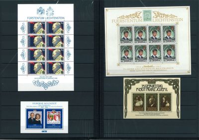 several stamps are on display on a black board with a picture of a man and a woman