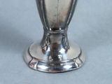 a silver vase that is sitting on a table