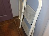a white step stool next to a purple door