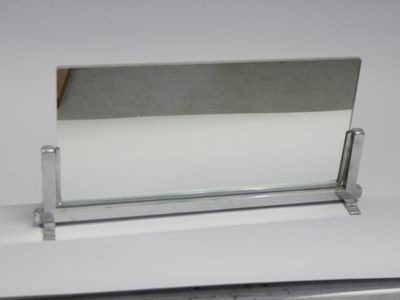un porte-cartes de visite en verre posé sur une surface blanche