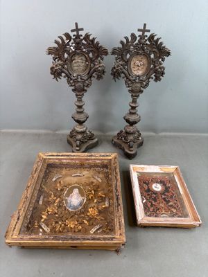 deux vases en argent richement décorés posés à côté d'une photo encadrée sur une table