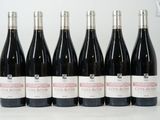 six bouteilles de vin rouge sont alignées sur une table