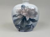 a white vase with a blue and white flower on it