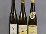 trois bouteilles de vin sont alignées sur une table
