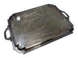 a metal tray with a handle on a white surface