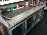 a kitchen with a counter and a tv in the background