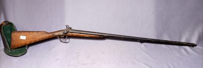 an old rifle is laying on a white sheet with a wooden handle