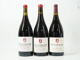 trois bouteilles de vin rouge sont alignées sur une surface blanche