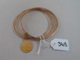 plusieurs bracelets en or avec une pièce d'or sur fond blanc