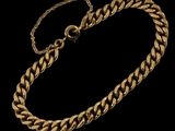 un bracelet à chaîne en or avec un fermoir sur fond noir