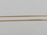a pair of gold chains on a white surface