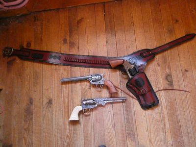 deux pistolets et un étui posés sur un plancher en bois