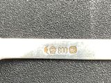 a silver spoon with a handle on a black surface