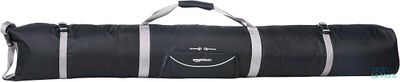 Le grand sac de voyage noir est posé sur une surface blanche.