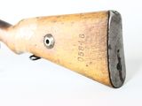 a wooden rifle with a metal handle on a white surface