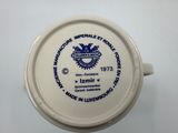 a white cup with a blue and white design on it