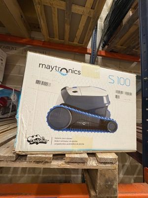 une caisse de Maytronics posée sur une palette dans un entrepôt