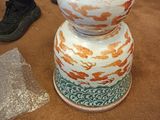 a vase that is sitting on the floor next to a shoe