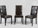 trois fauteuils en cuir marron placés les uns à côté des autres sur une surface blanche