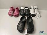 Plusieurs paires de Crocs sont alignées sur une table