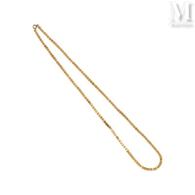 un collier en or avec une chaîne sur fond blanc