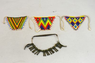 Quatre cache-sexes, trois en triangle ornés de motifs géomét…