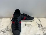 a pair of black and red sneakers on a marble surface