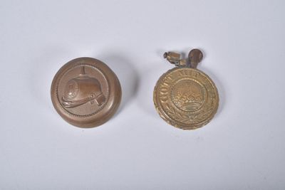 deux petites médailles d'or sont posées l'une à côté de l'autre sur une surface blanche