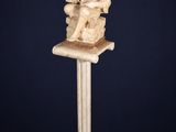 une statue représentant un homme assis au sommet d'un piédestal