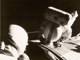 un homme assis à l'arrière d'une voiture, avec une boîte sur la tête