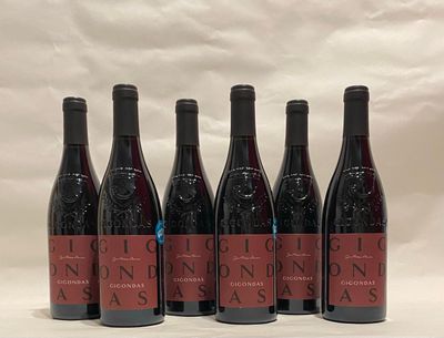 six bottles of wine are lined up in a row on a table