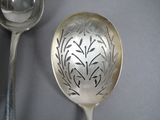 a silver spoon and a spoon with a design on it