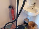 un aspirateur posé par terre à côté d'un évier